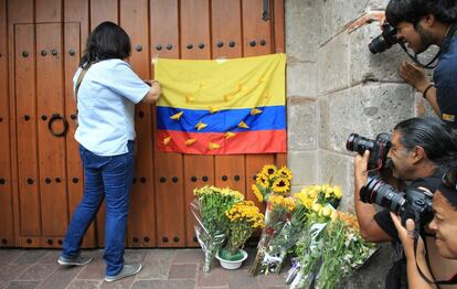 Una ciudadana colombiana coloca una bandera de su país en el portón de la casa del escritor, en Ciudad de México.