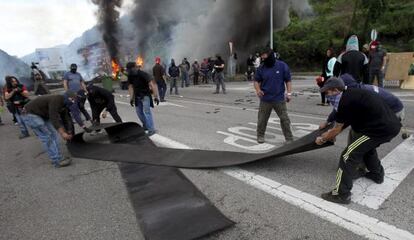 Un grupo de mineros cortando el tr&aacute;fico con una barricada