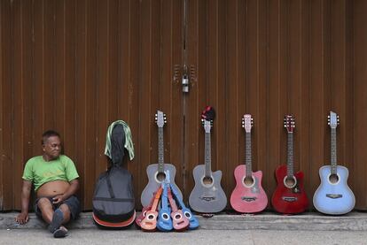 Un vendedor de guitarras espera a los clientes en una calle de Manila (Filipinas).