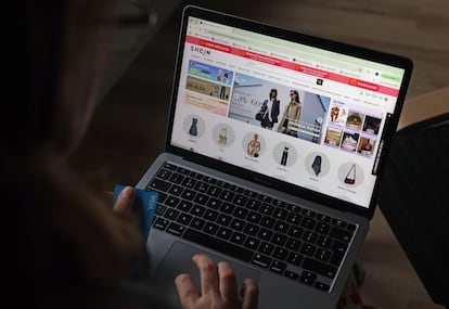 Una mujer realiza compras a través de una página web desde su casa.