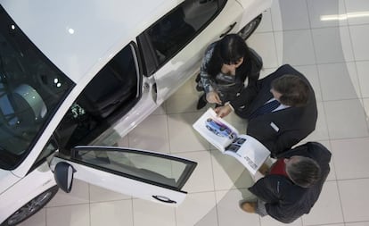 Un vendedor atiende a una pareja en un concesionario de coches en Madrid.