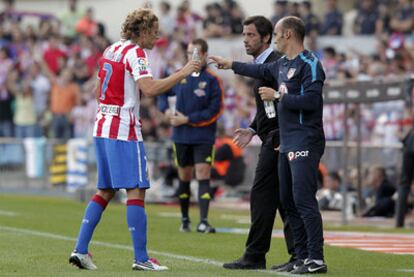 Forlán recibe agua de Jordi García mientras Quique  le da instrucciones en un partido en el Calderón.