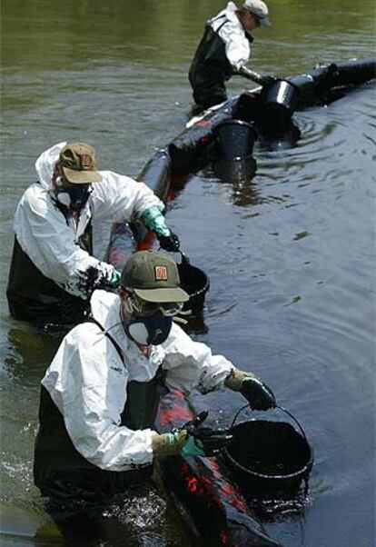 Técnicos de Medio Ambiente retiran fuel vertido en el río Fluvià, en junio de 2004.