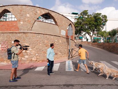 Unos periodistas preguntan a un viandante en la urbanización Benyamina en Torremolinos (Málaga), lugar donde fue hallado el cuerpo de una mujer este jueves.