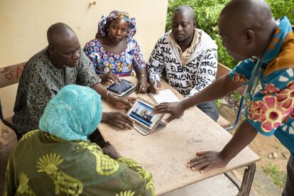 Mahamadou Hassaye Maïga, director de la escuela Banguetabá B, sujeta una tablet y muestra a cuatro profesores del centro el método pedagógico para trabajar con grandes grupos.