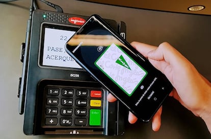 Una persona paga con la tarjeta de El Corte Inglés desde el móvil a través de la plataforma Samsung Pay.