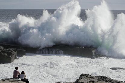 Dos personas observan las olas golpear en la costa de la ciudad de Shirahara, prefectura de Wakayama, en el centro de Japón, debido a los fuertes vientos al acercarse la llegada del tifón Jebi.