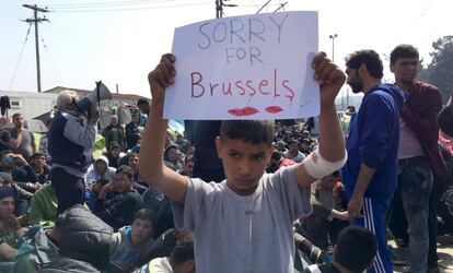 Un ni&ntilde;o refugiado ense&ntilde;a el martes una pancarta con el mensaje &quot;Lo siento por Bruselas&quot; cerca de frontera greco-macedonia.