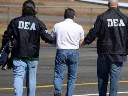 US Drug Enforcement Administration agents lead a suspect away.