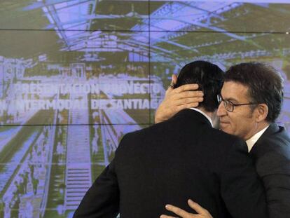 El presidente de la Xunta, Alberto Núñez Feijóo, abraza al ministro de Fomento, Íñigo de la Serna, tras presentar la nueva estación intermodal de Santiago.