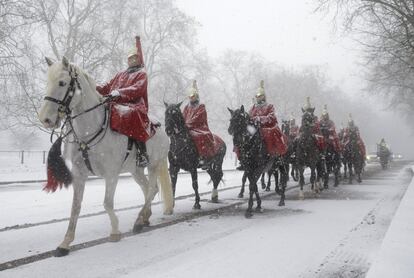 Los miembros del Household Cavalry regresan a sus cuarteles cuando cae la nieve en Londres (Reino Unido).