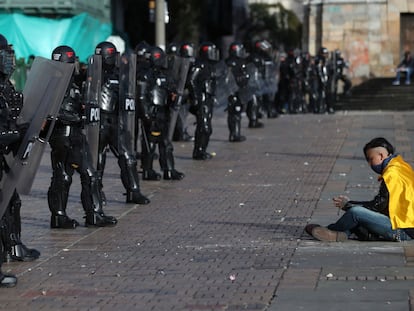 Un manifestante se sienta frente a una fila de policías, el 21 de septiembre de 2020 en Bogotá.