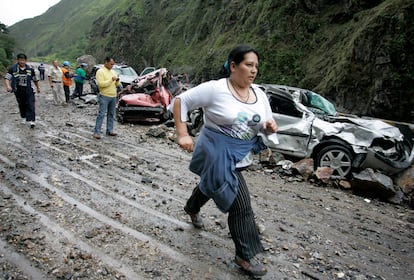 Una mujer pasa junto a unos carros dañados por un terremoto en Quetame, al sureste de Bogotá.