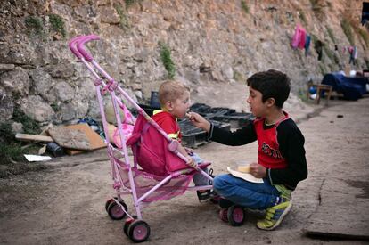Un niño alimenta a su hermano en el campo de refugiados del municipio de Souda, en la isla de Chios (Grecia). El 15 de septiembre se produjo una protesta donde los locales exigían la salida de unos 3.500 refugiados y migrantes mantenidos allí tras haber superado frontera tras frontera en los Balcanes.