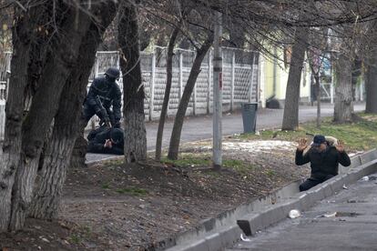 Un policía antidisturbios detiene a dos manifestantes durante una operación antiterrorista en una calle de Almaty, este sábado.