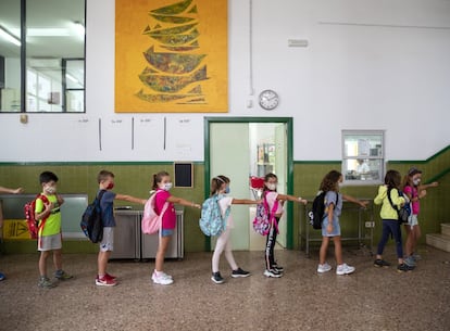 Un grupo de niños mantiene la distancia de seguridad antes de acceder al aula en el primer día del curso escolar en Valencia.