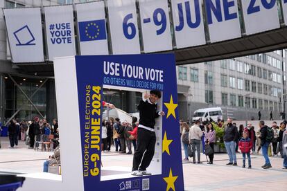 Un hombre junto a un cartel que llama al voto para las elecciones europeas, en Bruselas el 4 de mayo. 