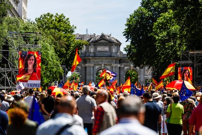 Manifestantes siguen la intervención de la presidenta de la Comunidad de Madrid, Isabel Díaz Ayuso, en dos pantallas en la calle Alcalá de la capital.