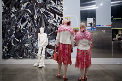 Dos visitantes contemplan la escultura <i>Adam,</i> del artista polaco Pawel Althamer, en el <i>stand</i> de la galería berlinesa Neugerriemschneider.