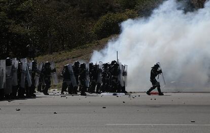 Miembros de la Guardia Nacional se protegen durante enfrentamientos con estudiantes de Ayotzinapa en la autopista del Sol este viernes en Guerrero.