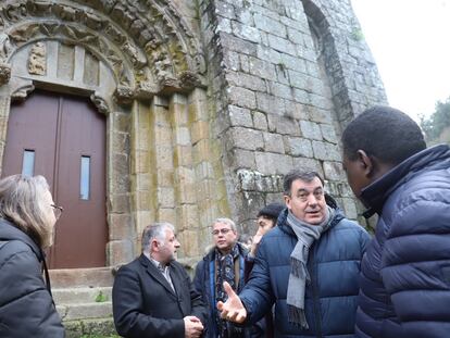 El consejero gallego de Cultura, segundo por la derecha, habla con el párroco en presencia de miembros del Ayuntamiento y del investigador Prado-Vilar, el pasado día 18 ante la fachada de la iglesia del Monasterio de Carboeiro.
