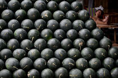 Un trabajador duerme cerca de un puesto de sandas en un mercado en Manila. Los filipinos creen que disponer en su casa de 12 frutos redondeados diferentes, representando cada uno de ellos los meses del a?o, antes del Da de A?o Nuevo, dan la bienvenida a la prosperidad.