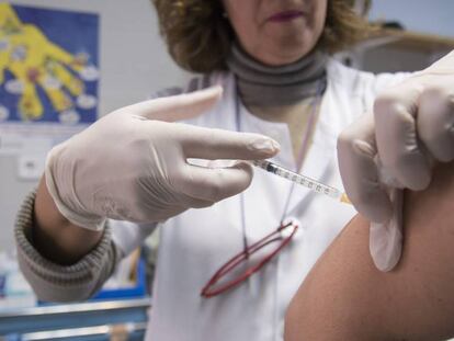 Una infermera posa una vacuna a un pacient