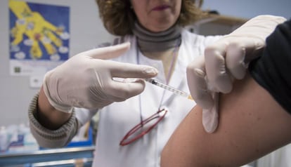 Una infermera posa una vacuna a un pacient