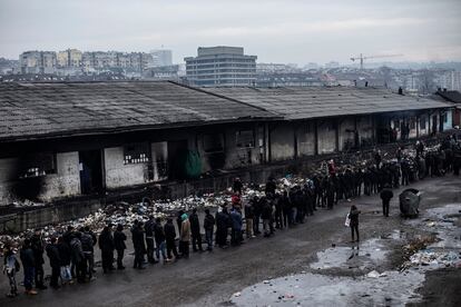 Refugiados y migrantes hacen cola para un reparto de comida organizado 
en la vieja estación por voluntarios.