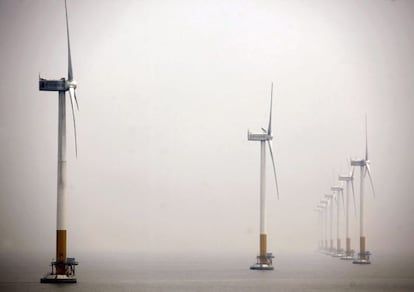 Molinos de viento emplazados cerca de la costa en el mar.