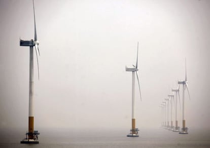 Molinos de viento emplazados cerca de la costa en el mar. 