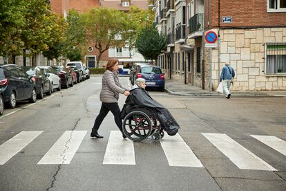 La auxiliar de ayuda a domicilio Mercedes Molina, de 57 años, acompaña a la usuaria Nicolasa Santana, de 92, a un centro de día en Valladolid.
