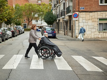 La auxiliar de ayuda a domicilio Mercedes Molina, de 57 años, acompaña a la usuaria Nicolasa Santana, de 92, a un centro de día en Valladolid.