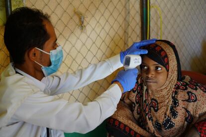 Yaseem, enfermero de MSF, revisa la temperatura de una paciente en la clínica móvil Al-Khuseif en Marib, Yemen. Tanto ella como su hermana tienen tos, diarrea y dolores de cabeza. Ambas son dos de las hijas de Abdu Sabit.