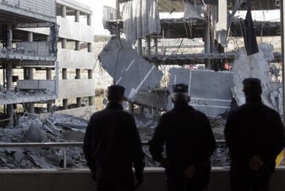 Varios policías contemplan el aparcamiento de la T-4 de Barajas tras la explosión de un coche bomba.