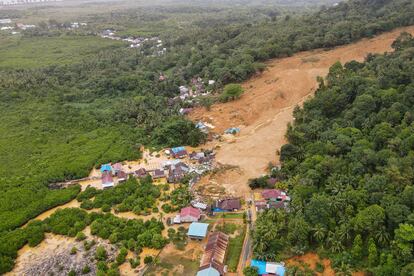 This aerial picture taken on March 7, 2023 shows a rescue team using backhoe to search for victims among houses that were destroyed after being hit by landslides at Pelimpak village in Natuna Islands.