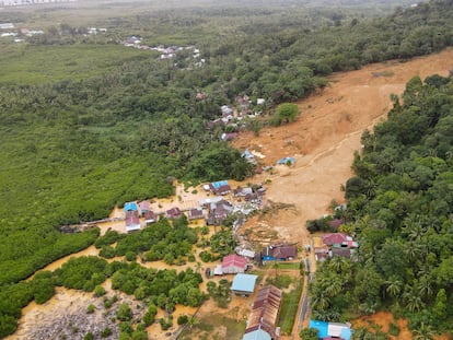This aerial picture taken on March 7, 2023 shows a rescue team using backhoe to search for victims among houses that were destroyed after being hit by landslides at Pelimpak village in Natuna Islands.