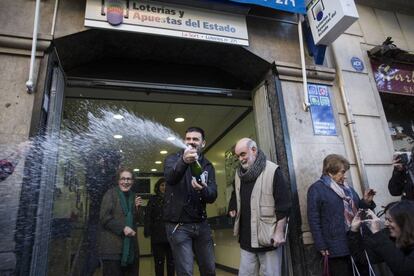 Els venedors de loteria i els guanyadors de l'administració de Travessera de Gràcia 244 celebren el primer premi.