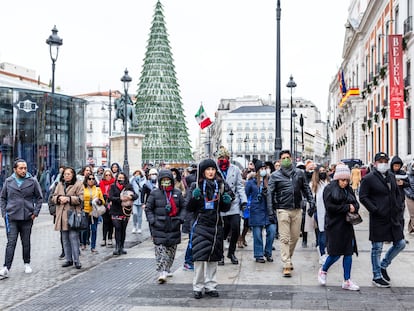 Un grupo de turistas pasean por la Puerta del Sol de Madrid, este diciembre.