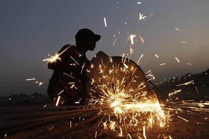 Un obrero corta hierro en una obra en Ahmadabad (India).