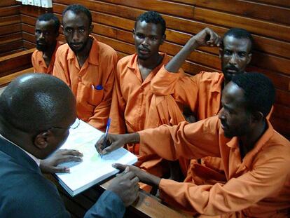 El abogado Francis Kadima, de espaldas, habla con un grupo de piratas en el juzgado de Mombasa.