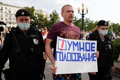 La policía rusa detiene a un activista con una pancarta en la que se lee "Voto inteligente", el pasado agosto en Moscú. 
