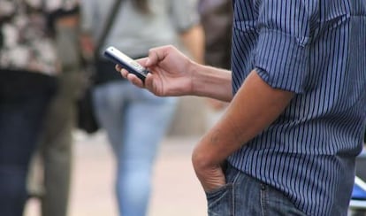 Homem checa o celular em Montevidéu.