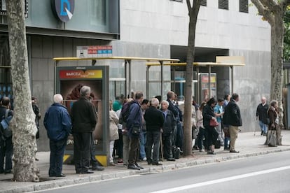 Persones esperant avui l'autobús a la Gran Via.