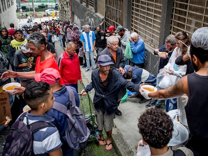 En São Paulo, personas en condición de calle hacen fila para recibir alimentos de un grupo de voluntarios, el 21 de octubre del 2022.