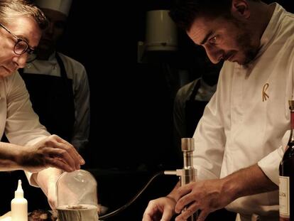 Joan Roca y, a la derecha, su hermano Jordi preparan un plato con madera. 