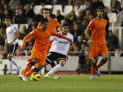 Vela controla el balón ante la presión de Banega