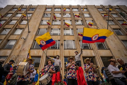 Un grupo de músicos y actores ondean banderas colombianas, durante la marcha. 