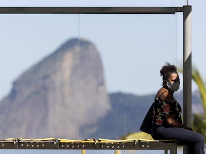 Una mujer espera este lunes en una parada de autobús cerca de Río de Janeiro.