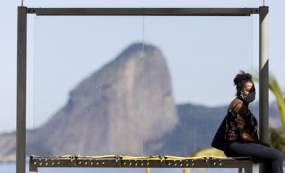 Una mujer espera este lunes en una parada de autobús cerca de Río de Janeiro.